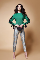 Sexy beautiful woman fashion glamour model brunette hair makeup wear knitted sweater green trousers clothes for every day casual party style jewelry date walk girlfriend skinny body shape studio.