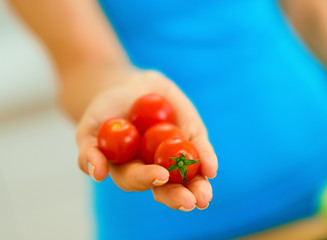 Closeup on cherry tomato in hand of woman