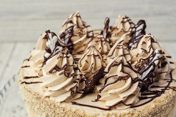 sponge cake with cream decorated by meringue and chocolate