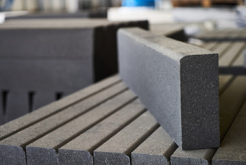 Concrete road curbs at the factory for the production of cement products, paving slabs, construction material for a new sidewalk