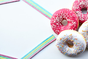 White and pink donuts and jelly candies on the white background isolated. Copy space.