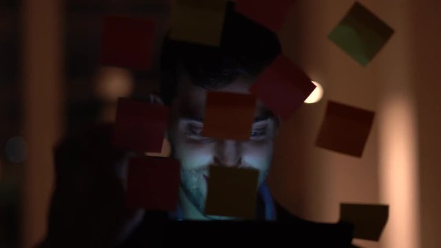Business man working late building new ideas with sticky note paper on window