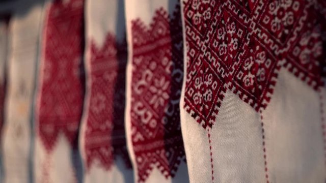 National Ukrainian rushnyk in warm sunlight. A symbol of Ukraine, traditional ethnic towel with hand embroidered ornament pattern. White cloth with multicolor needlework texture, close-up. 