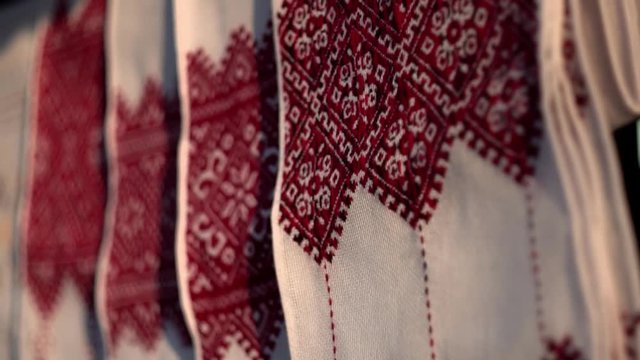 National Ukrainian rushnyk in warm sunlight. A symbol of Ukraine, traditional ethnic towel with hand embroidered ornament pattern. White cloth with multicolor needlework texture, close-up. 