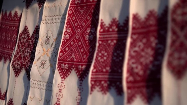 National Ukrainian rushnyk in warm sunlight. A symbol of Ukraine, traditional ethnic towel with hand embroidered ornament pattern. White cloth with multicolor needlework texture, close-up. 