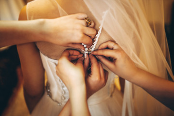 Pretty bride dressing up before wedding ceremony