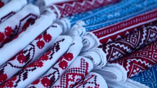 A symbol of Ukraine, national Ukrainian rushnyk. Traditional ethnic towel with hand embroidered cross stitch ornament pattern. White cloth with multicolor needlework texture, close-up. 
