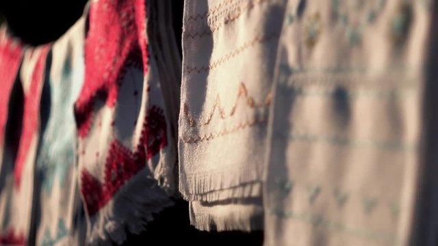 National Ukrainian rushnyk in warm sunlight. A symbol of Ukraine, traditional ethnic towel with hand embroidered ornament pattern. White cloth with multicolor needlework texture, close-up. 