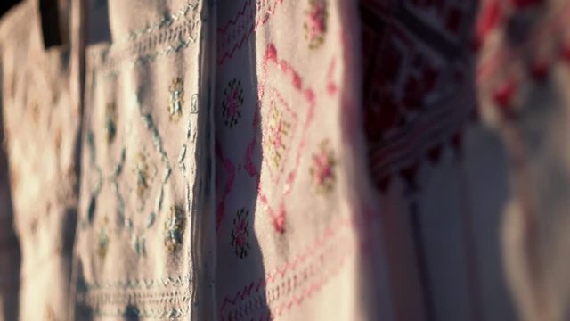 National Ukrainian rushnyk in warm sunlight. A symbol of Ukraine, traditional ethnic towel with hand embroidered ornament pattern. White cloth with multicolor needlework texture, close-up. 
