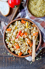 Porridge from bulgur with vegetables: carrots, bell peppers, onions, zucchini