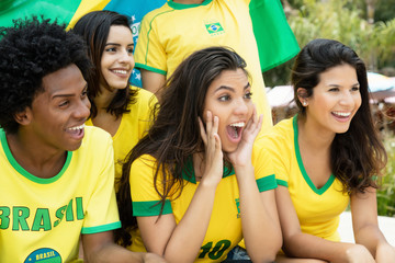 Laughing brazilian soccer fans with flag