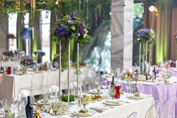 beautiful hydrangea bouquets in vases on high stands. Flower arrangement on tables at luxury wedding reception in restaurant. stylish decor and adorning
