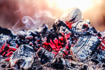 Hot coals fire with smoke. Texture on a picnic outdoor
