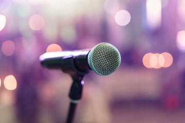 Close up microphone on stage in concert hall restaurant or conference room. Blurred background. Copy space