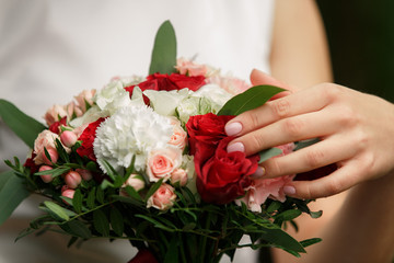 Obraz na płótnie Canvas Wedding day. Beautiful bride with classic manicure holding fresh wedding bouquet