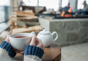 Woman hands holding ceramic cup of tea