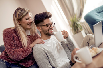 Smiling couple using laptop at home
