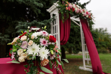 Wedding arch for wedding ceremony. Beautiful marsala wedding decor and decoration with fresh flowers. Selective focus