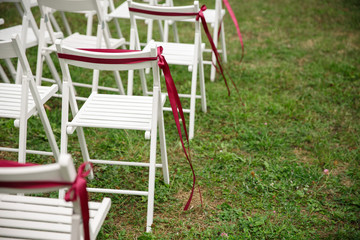 Chairs with marsala decor for wedding ceremony