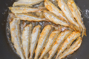 Cooking fried fish smelt rolled in flour