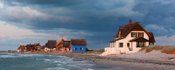 Strandvillen auf der Halbinsel Graswarder in Heiligenhafen in Schleswig-Holstein an der Ostsee bei Sonnenuntergang im letzten Sonnenlicht © Thorsten Schier
