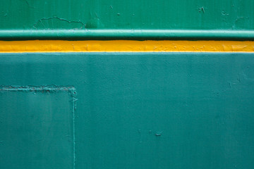 Green background. Painted metal surface. The yellow line on a green background. Metal painted in green and yellow.