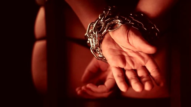 young girl with hands shackled behind his back chain imprisoned her master