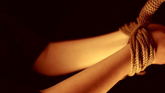 Master binds the hands of a young girl submissive / BDSM theme