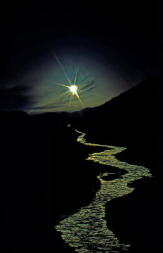 Midnight sun and Eagle River near Eagle Plains, Dempster Highway, Yukon Territory. During the summer months, the sun is still above the horizon at midnight 