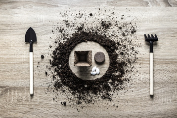 wooden background concept earth grounded circle dish spoon fork fork rake texture planting peat...