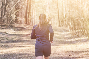 Sporty girl flees in the woods from the back
