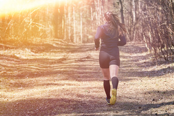 Sporty girl flees in the woods from the back