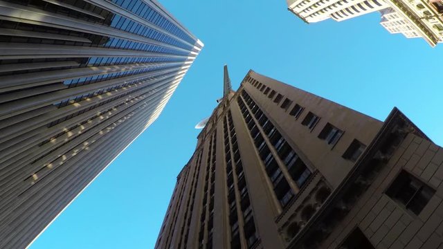 BOTTOM UP, CLOSE UP: Modern airplane flies over towering skyscrapers in metropolitan city. Large transatlantic aircraft flies above the stunning New York City skyscrapers on perfect sunny spring day.