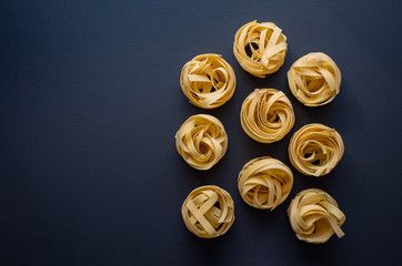 Italian pasta fettuccini on a black background.