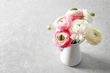 Vase with beautiful ranunculus flowers on light background