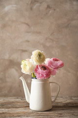 Vase with beautiful ranunculus flowers on wooden table