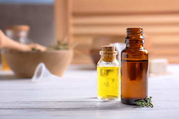 Bottles with essential oils on wooden table