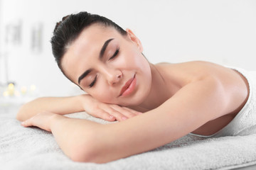 Obraz na płótnie Canvas Young woman lying on massage table in spa salon