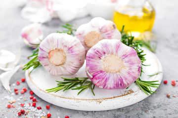 Obraz na płótnie Canvas Garlic. Fresh garlic, oil and rosemary on kitchen table