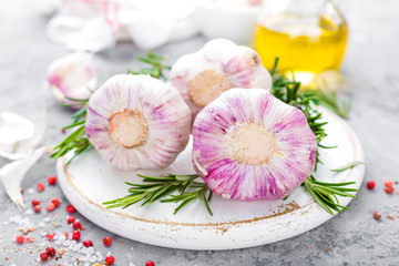 Fototapeta na wymiar Garlic. Fresh garlic, oil and rosemary on kitchen table