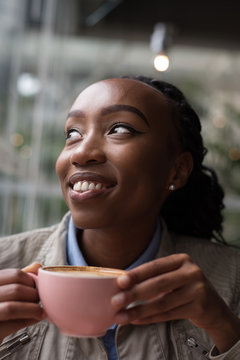 Smiling woman holding a coffee cup and looking away