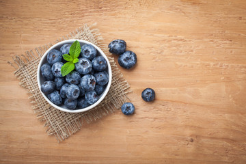 Blueberry on wooden table background. Ripe and juicy fresh picked blueberries closeup. Berries closeup top view with copy space