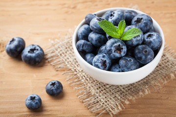 Blueberry on wooden table background. Ripe and juicy fresh picked blueberries closeup. Berries closeup top view with copy space