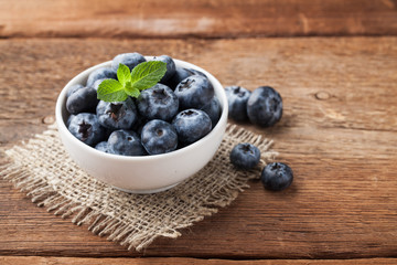 Blueberry on wooden table background. Ripe and juicy fresh picked blueberries closeup. Berries closeup with copy space