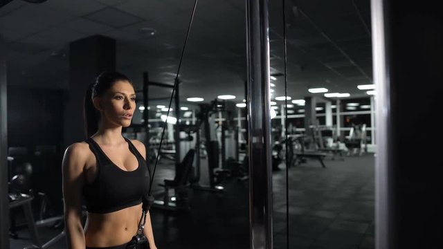 Sportive woman doing triceps cable pushdown exercise, training workout program