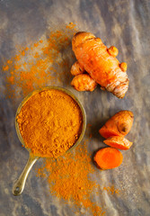 Overhead view of turmeric powder and root