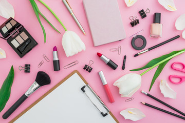 Composition with tulips flowers, cosmetics and accessory on pink background. Top view. Flat lay. Home feminine desk.
