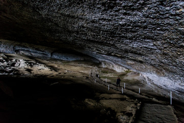 two men walking along pathway in the Milondon Cave, Puerto Natales, Patagonia