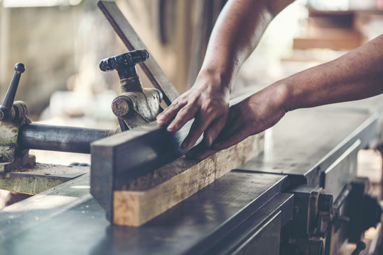 Background image of woodworking workshop: carpenters work table with different tools and wood cutting stand, vintage filter image