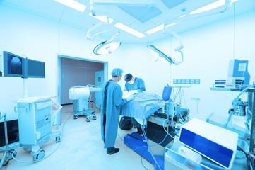 Two of veterinarian surgery in operation room take with art lighting and blue filter